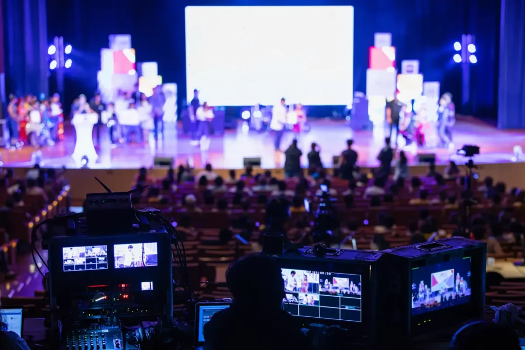 A trusted AV partner overseeing the live production with equipment and audience in view