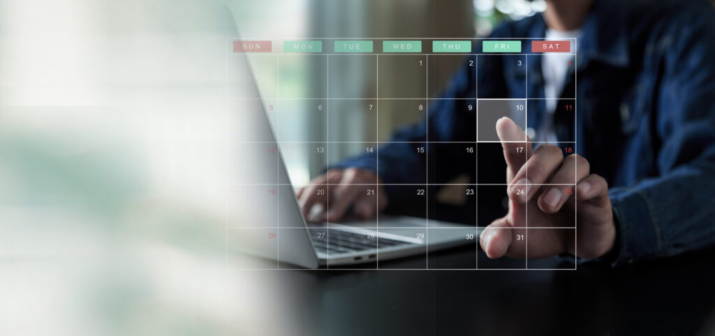 Man at laptop planning with a calendar